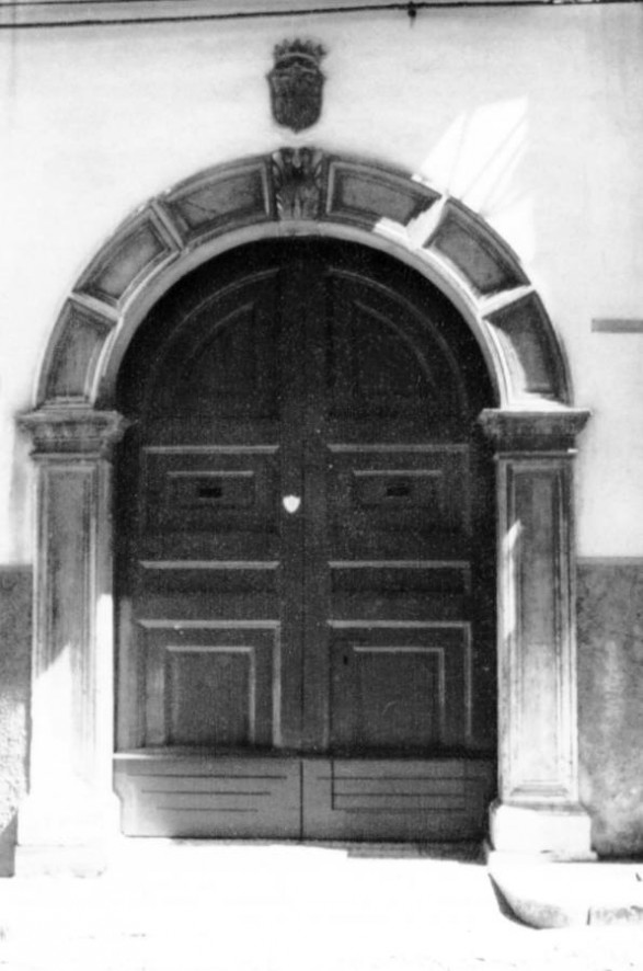 Fig. 33 Corso Matteotti 61. Ampio portale ad arco a tutto sesto con il frontespizio ripartito in sei parti di uguale ampiezza ed evidenziato da comici in rilievo ed al centro lo stemma in chiave d'arco raffigurante a bassorilievo una palma; in alto è murato un secondo stemma di stile gentilizio a scudo, coronato e quadripartito con la rappresentazione a bassorilievo di figure simboliche; imposte dei piedritti a capitello e basi rimarcate, con modanature nei piedritti; dà accesso all'ex-palazzo Piccirella. Particolare: Duplice stemma, di cui uno in chiave d'arco (a bassorilievo, figura di palma con la punta ripiegata in avanti) e l'altro situato al di sopra dell'arco di forma a scudo quadri partito con raffigurazioni all'interno di quattro figure a bassorilievo: torre, ulivo, cipresso e leone rampante. Fig. 33 Corso Matteotti 61. Ampio portale ad arco a tutto sesto con il frontespizio ripartito in sei parti di uguale ampiezza ed evidenziato da comici in rilievo ed al centro lo stemma in chiave d'arco raffigurante a bassorilievo una palma; in alto è murato un secondo stemma di stile gentilizio a scudo, coronato e quadripartito con la rappresentazione a bassorilievo di figure simboliche; imposte dei piedritti a capitello e basi rimarcate, con modanature nei piedritti; dà accesso all'ex-palazzo Piccirella. Particolare: Duplice stemma, di cui uno in chiave d'arco (a bassorilievo, figura di palma con la punta ripiegata in avanti) e l'altro situato al di sopra dell'arco di forma a scudo quadri partito con raffigurazioni all'interno di quattro figure a bassorilievo: torre, ulivo, cipresso e leone rampante.