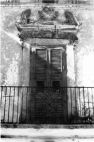 Fig. 2 Via della Vittoria 4. Balcone (stile barocco) con architrave decorato a motivi floreali e con volute laterali; è sormontato da frontone e timpano pure decorati. Particolare: Architrave con volute laterali, sormontato da frontone e timpano; entrambi sono decorati con elementi a motivi floreali a bassorilievo.