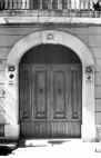Fig. 13 Corso Matteotti 158. Ampio portale ad arco a tutto sesto con stemma in chiave d'arco di forma trapezoidale contenente al centro inquadrata una figura semisferica a bassorilievo; parimenti si nota nelle imposte dei piedritti. Particolare: Stemma in chiave d'arco di forma trapezoidale con al centro la figura di una semisfera a bassorilievo inquadrata '1850'.