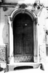 Fig. 15 Corso Giannone 255. Portale ad arco policentrico con chiave d'arco di forma trapezoidale con iscrizione, poggiante su imposte dei piedritti e basi rimarcate; modanature sui vari elementi. Particolare: Chiave d'arco di forma trapezoidale con iscrizione su due righe delle lettere sovrapposte 'L' e 'V' (Luigi Vigilante) e della data '1931'.
