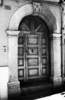 Fig. 21 Corso Giannone 110. Portale ad arco a tutto sesto con stemma in chiave d'arco di forma trapezoidale decorato e datato, con imposte dei piedritti a capitello e basi rimarcate. Particolare: Stemma in chiave d'arco di forma trapezoidale decorato con elementi a bassorilievo ed iscrizione ai lati: 'A' e 'D' e sotto: '1857'.