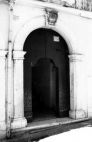 Fig. 22 Corso Giannone 108. Portale ad arco a tutto sesto con stemma in chiave d'arco a protiride, decorato con elementi a bassorilievo di tipo floreale e con iscrizione data; con imposte dei piedritti a capitello e basi rimarcate; con modanature nei piedritti e nell'arco. Particolare: Stemma in chiave d'arco a protiride con decorazioni a bassorilievo di tipo floreale e con iscrizione nell'intradoso della chiave: '1851'.