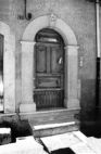 Fig. 25 Corso Giannone 92. Portale ad arco a tutto sesto con chiave d'arco a forma pentagonale datato, poggiante su imposte dei piedritti a capitello a basi rimarcate. Particolare: Chiave d'arco con iscrizione su due righe: 'A.D.' e '1869'.