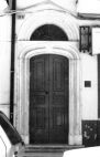 Fig. 30 Corso Matteotti 116. Portale ad arco a sesto ribassato con stemma a bassorilievo raffigurante iscrizione e data, con luce sovrastante a lunetta e con modanature sui piedritti e sugli archi. Particolare: Stemma in chiave d'arco, con iscrizione a bassorilievo delle lettere iniziali 'C' e 'S' sovrapposte, riferite al nome dell'antico proprietario (Giustiniano Serrilli) e sotto la data di esecuzione '1881'.