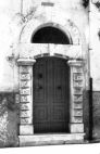 Fig. 31 Corso Matteotti 97. Portale ad arco a sesto ribassato con chiave trapezoidale, con imposte dei piedritti a capitello; con piedritti decorati a bugne. Particolare: Chiave d'arco di forma trapezoidale molto stretta, sovrastata da luce di forma a lunetta con arco a tutto sesto.