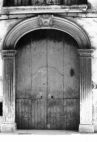 Fig. 32 Corso Matteotti 91. Ampio portale ad arco leggermente ribassato con stemma in chiave d'arco di forma trapezoidale contenente una testa di fanciullo ed elementi decorativi; con imposte a capitello e basi rimarcate e con modanature nell'arco e nei piedritti; ex - palazzo D'Orsi-Villani. Particolare: Stemma in chiave d'arco raffigurante a bassorilievo una piccola testa di fanciullo, incorniciata da elementi decorativi.