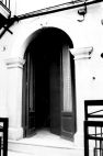 Fig. 37 Via Solferino 5. Portale ad arco a tutto sesto con stemma in chiave d'arco decorato a bassorilievo con fregio adorno di elementi floreali e con iscrizione; imposte dei piedritti a capitello e basi rimarcate. Particolare: Stemma in chiave d'arco con fregio, decorazione con motivi floreali ed iscrizione: 'A.D. 1876'.
