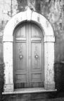 Fig. 39 Via Verdi 12. Portale ad arco a tutto sesto con chiave d'arco di forma pentagonale contenente iscrizione, poggiante su imposte dei piedritti e basi leggermente rimarcate. Particolare: Chiave d'arco di forma pentagonale con iscrizione '1881 F.N.'.
