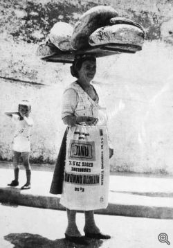 Foto di G. Bonfitto. Una donna che trasporta numerosi 'parrozze'
